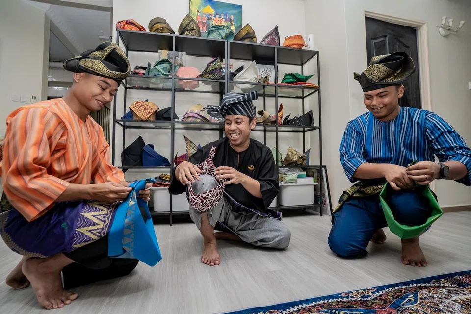 KONGSI ILMU: Encik Muhammad Fairuz Zazali (tengah) kini melatih dua belia, Encik Syahzyad Syawqie Kamal Lutfie (kiri) dan Encik Mohammad Hazzreeq Mohammad Halim, dalam seni mengarang tanjak supaya warisan itu tidak pupus dan boleh diturunkan kepada generasi seterusnya.