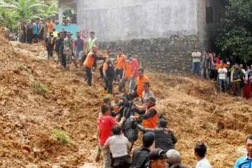 MEMINDAHKAN MAYAT: Anggota pasukan mencari dan menyelamat memindahkan mayat dari tapak tanah runtuh di perkampungan Tegal Panjang, Sukabumi, Jawa Barat. - Foto JAKARTA POST