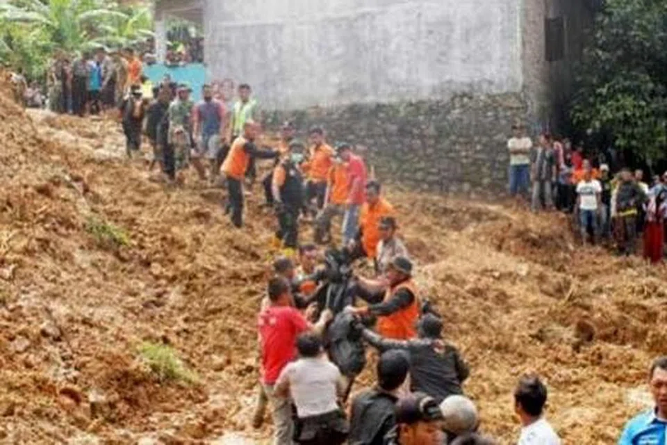MEMINDAHKAN MAYAT: Anggota pasukan mencari dan menyelamat memindahkan mayat dari tapak tanah runtuh di perkampungan Tegal Panjang, Sukabumi, Jawa Barat. - Foto JAKARTA POST