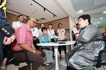 Presiden Tharman Shanmugaratnam (kiri), yang diiringi Puan Jane Ittogi (duduk bersebelahannya), sedang mendengar pengalaman pemandiri barah, Cik Wendy Tan (kanan) semasa pembukaan Pusat Pemulihan Pusat Barah Nasional Singapura - Persatuan Barah Singapura (NCCS-SCS) pada 1 Jun.