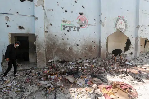 Penduduk Palestin memeriksa kesan kerosakan serangan udara Israel ke atas sebuah gudang bantuan kemanusiaan di kem pelarian Al-Nuseirat, tengah Gaza, pada 14 Mac.
