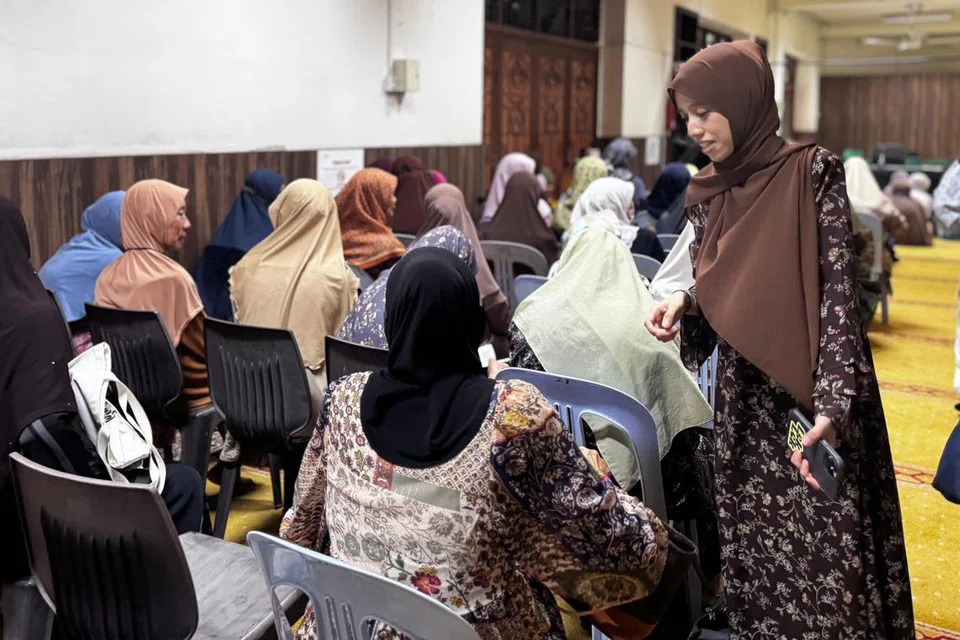 Cik Nurhaslinda Shariff (kanan, berdiri) bersama jemaah Muslimah sebelum bermulanya kuliah Fardu Ain sebagai sebahagian daripada program pengajian agama di masjid tersebut. 