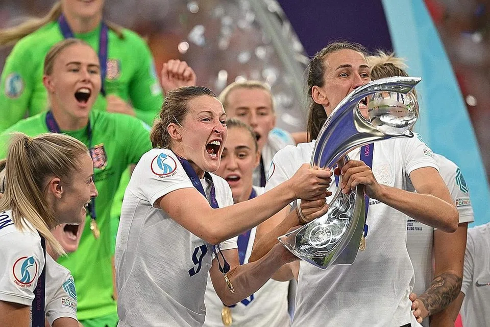 SAMBUT KEJAYAAN: Penyerang England Ellen White (kiri) dan pemain midfield Jill Scott (kanan) mengangkat trofi selepas pasukan itu menjuarai Euro 2022 Wanita UEFA di Stadium Wembley kelmarin. - Foto AFP