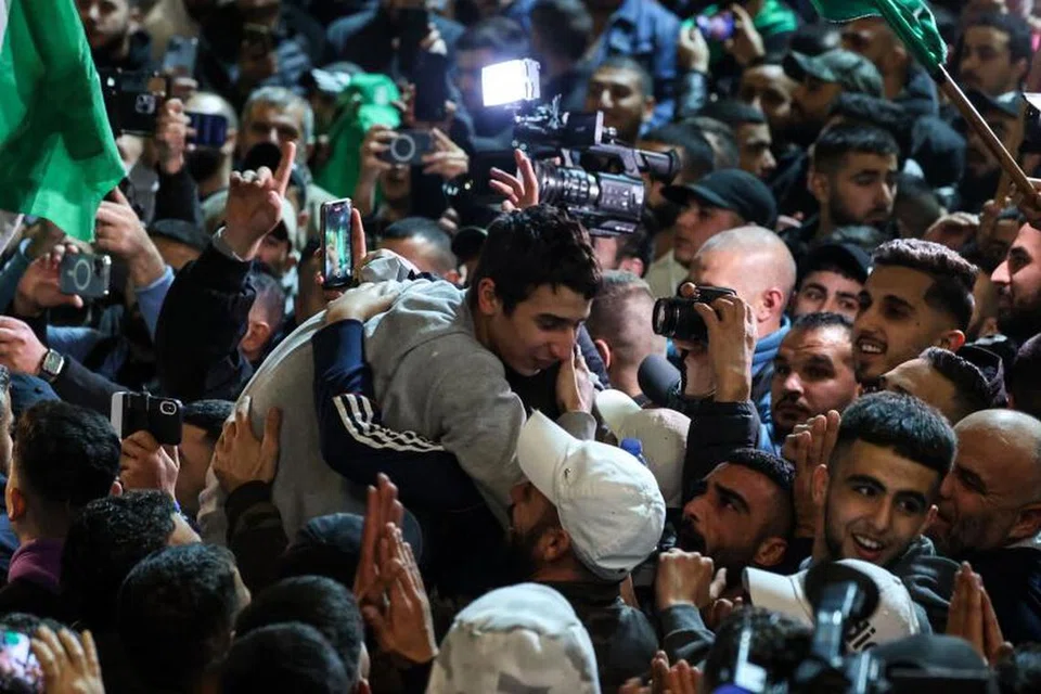 PEMBEBASAN YANG DINANTI: Tahanan Palestin (memakai sut kelabu) bersyukur dan mendapat kata-kata perangsang daripada penyokong selepas dibebaskan daripada penjara Israel. 