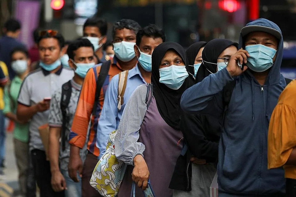 JAGA KESELAMATAN: Penumpang memakai pelitup sambil beratur untuk menaiki bas di stesen bas di Kuala Lumpur. Memakai pelitup, selain mengamalkan jarak selamat dan menjaga kebersihan diri, amat perlu dalam membendung penularan Covid-19. - Foto REUTERS