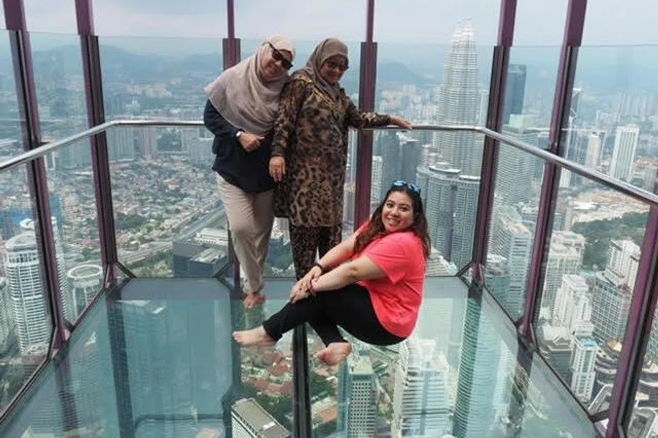 (kiri) Cik Chantek Lias bergambar bersama ibunya, Cik Seamah Sulaiman, dan anak keduanya, (duduk di lantai) Cik Diyanawati di Menara KL semasa bercuti.