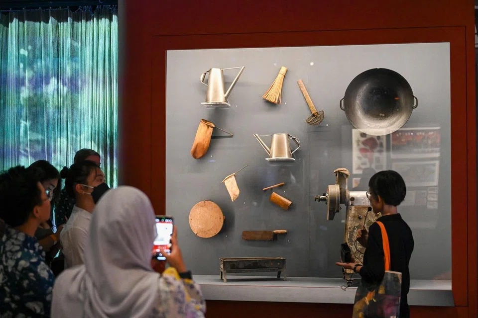 KHAZANAH LAMA: Orang ramai melihat peralatan dapur lama yang dipamerkan. Pameran Now Boarding: Experiencing Singapore Through Travel membawa pengunjung menyusuri sejarah Singapura dari tahun-tahun 1800-an hingga 2000-an dan meneliti identiti negara melalui lensa pelancongan sebagai bahasa visual. 