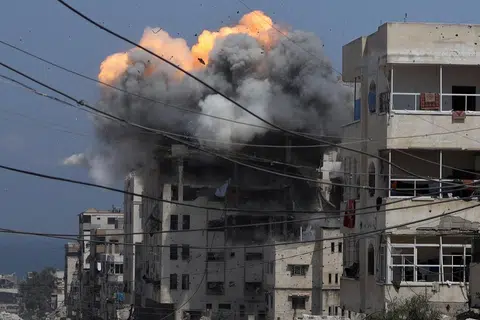 Asap dan api menjulang dari sebuah bangunan kediaman yang terkena serangan Israel di Bandar Gaza pada 21 Julai 2025.