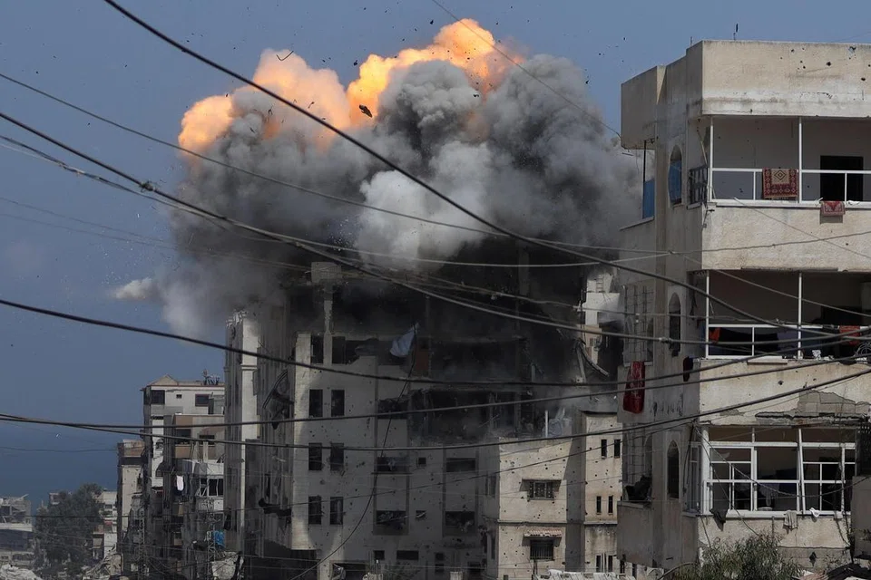 Asap dan api menjulang dari sebuah bangunan kediaman yang terkena serangan Israel di Bandar Gaza pada 21 Julai 2025.