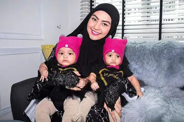 TERUS MENYUSUKAN BAYI WALAUPUN BERPUASA: Cik Juriah Aziz Ng memberi perhatian lebih kepada pemakanannya dalam Ramadan ini supaya dapat terus menghasilkan bekalan susu yang mencukupi untuk anak kembarnya, Madeenah Az-Zahraa (kiri) dan Mayeesha Ar-Rawdah. - Foto ZALEHA ABDUL KADER
