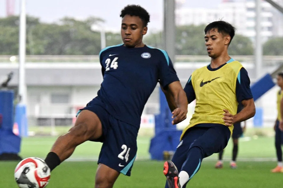 Pemain Singapura, Abdul Rasaq Akeem (kiri) dan Shah Shahiran beraksi ketika sesi latihan di Hab Bola Sepak Kallang.