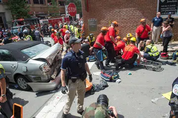 KEJADIAN NGERI: Sekumpulan paramedik memberi bantuan kecemasan kepada seorang wanita, selepas sebuah kereta merempuh kumpulan pembantah yang menentang perhimpunan nasionalis kulit putih di Charlottesville, semalam. - Foto AFP