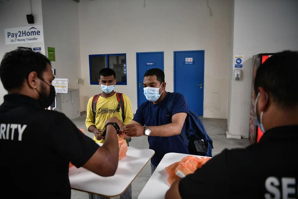 AMBIL MAKANAN: Encik Nadim Dowlat Gazi (baju biru) mengambil bubur untuk dirinya dan rakan-rakannya untuk berbuka puasa bersama apabila pulang ke dormitorinya di Choa Chu Kang Grove dari tempat kerja.