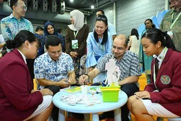 Menteri Pendidikan, Encik Desmond Lee (dua dari kiri), dan Setiausaha Parlimen Kanan (Pendidikan merangkap Pembangunan Negara), Dr Syed Harun Alhabsyi (dua dari kanan), mencuba aktiviti di Simposium Bahasa Ibunda (MTLS) ke-14.