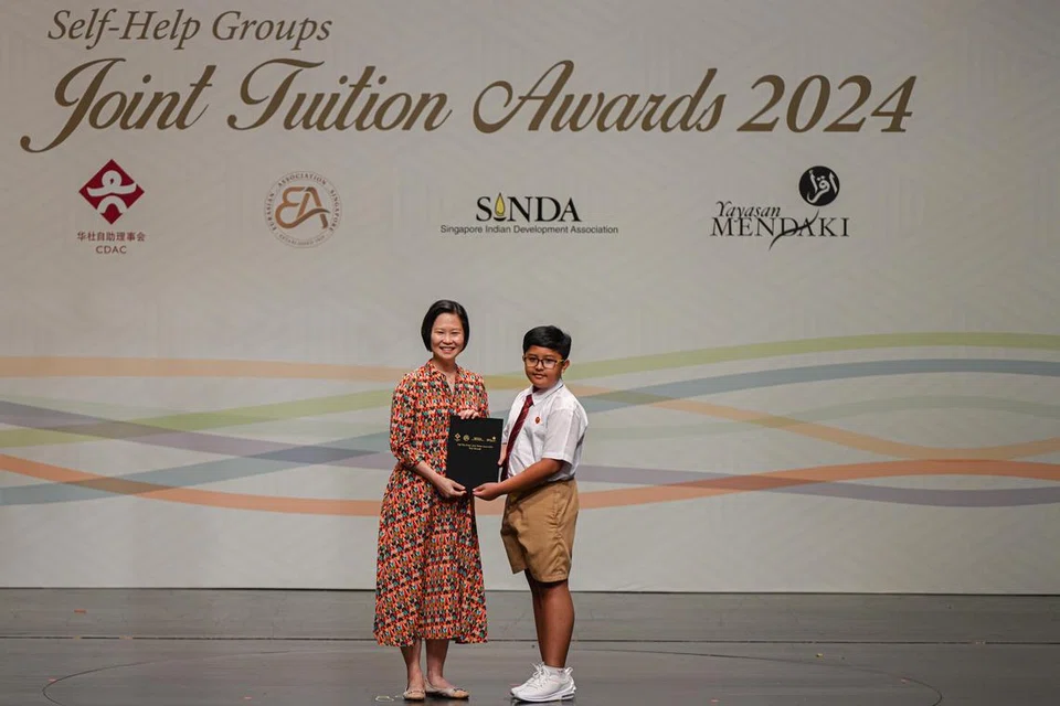 Fariz Ayril Farok (kanan) menerima anugerah Pelajar Keseluruhan Terbaik (PSLE) daripada Menteri Negara (Pendidikan merangkap Tenaga Manusia), Cik Gan Siow Huang, di Majlis Anugerah Tuisyen Bersama (JTA) 2024 di Politeknik Republik (RP) pada 24 Ogos. 