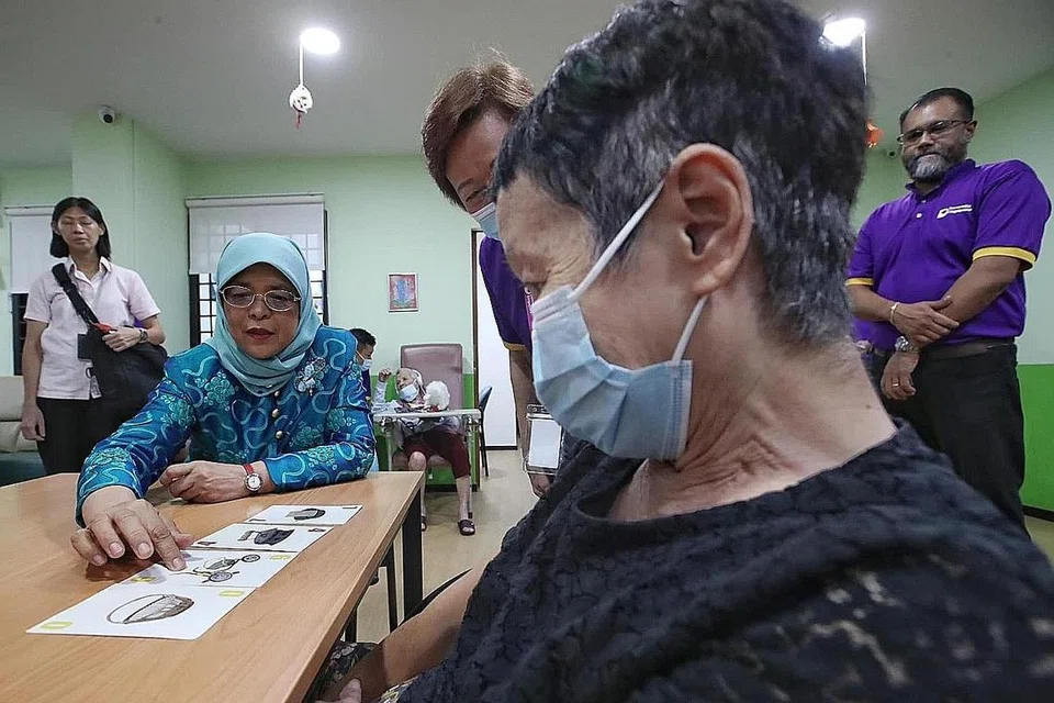 BERI SOKONGAN: Presiden Halimah Yacob meninjau kegiatan yang dijalankan di Pusat New Horizon bagi menyokong penghidap demensia serta penjaga mereka. - Foto MCI