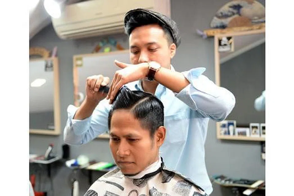 GAYA RAMBUT TERKINI: Encik Nor Muhammad Faiz Ismail, pemilik Deep Cuts, sedang menggayakan fesyen 'pompadour' pada rambut Encik Muhammad Musthaqim Zainal Abidin. - Foto ZAINAL YAHYA