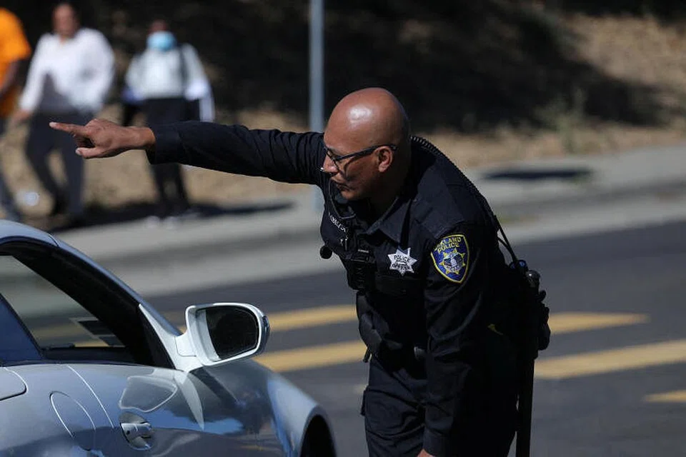 BERI ARAHAN: Seorang pegawai polis memberi arahan kepada para pemandu selepas kejadian tembakan di Oakland, California.