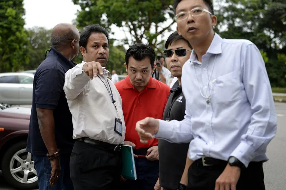 Lee Sze Yong (baju polo merah), yang dikatakan mendalangi penculikan Cik Cik Ng Lye Poh. dibawa balik ke Taman Sembawang bagi siasatan polis pada Januari 2014. 
