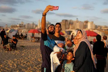 AMBIL SWAFOTO BERSAMA: Sebuah keluarga mengambil 'wefie' atau dalam bahasa Melayu, swafoto bersama, di pantai di Gaza City, Palestin. - Foto REUTERS