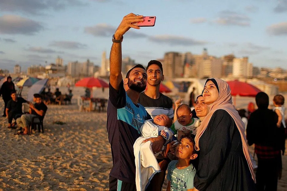 AMBIL SWAFOTO BERSAMA: Sebuah keluarga mengambil 'wefie' atau dalam bahasa Melayu, swafoto bersama, di pantai di Gaza City, Palestin. - Foto REUTERS