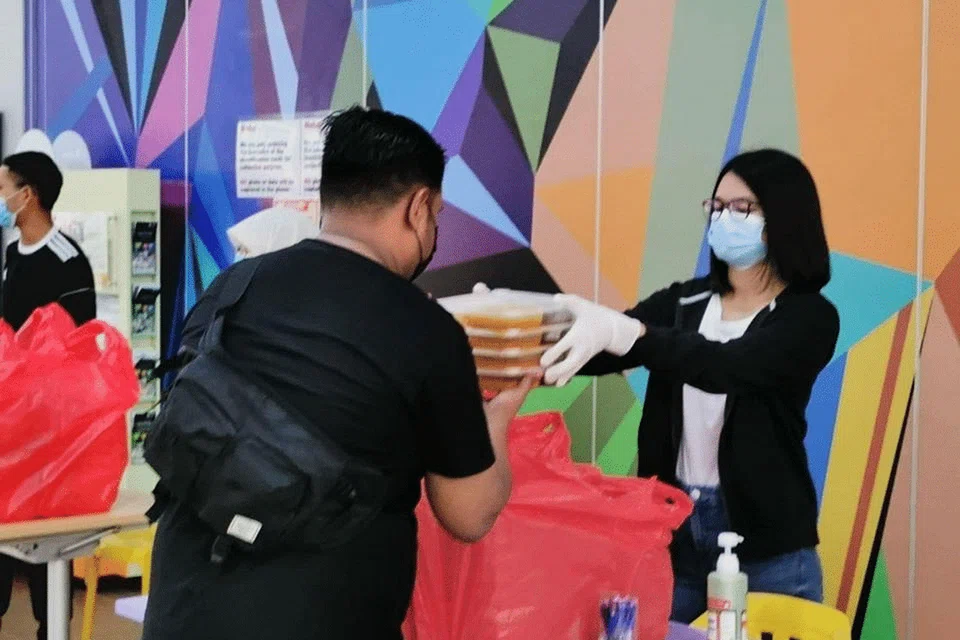 MENYINGSING LENGAN: Seorang relawan membantu mengagihkan makanan untuk berbuka puasa di salah sebuah Kelab Masyarakat di sini. 