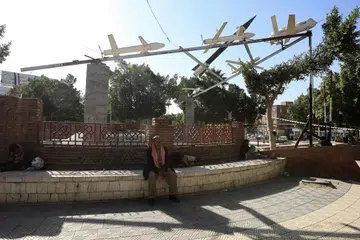 DRON: Penduduk Yaman duduk di hadapan dron dan peluru berpandu buatan Houthi yang dipamerkan di sebuah dataran di Sana’a, Yaman pada 10 Januari. 