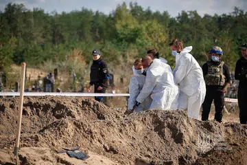 SELONGKAR KUBUR: Pegawai forensik menyelongkar kubur besar yang ditemui di bandar Lyman, yang ditawan semula oleh Ukraine baru-baru ini. Tentera Ukraine sebelum ini telah memasuki bandar Lyman di timur wilayah Donestsk, salah satu daripada empat wilayah yang Russia isytiharkan sebagai miliknya. IMF semalam mengumumkan bantuan tambahan kepada Ukraine. - Foto REUTERS