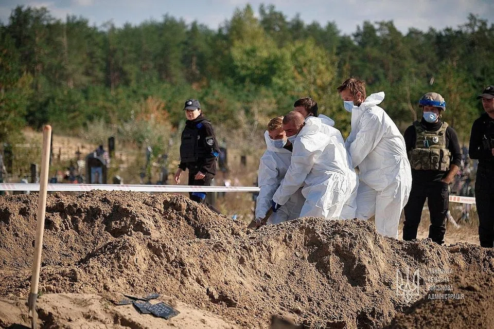 SELONGKAR KUBUR: Pegawai forensik menyelongkar kubur besar yang ditemui di bandar Lyman, yang ditawan semula oleh Ukraine baru-baru ini. Tentera Ukraine sebelum ini telah memasuki bandar Lyman di timur wilayah Donestsk, salah satu daripada empat wilayah yang Russia isytiharkan sebagai miliknya. IMF semalam mengumumkan bantuan tambahan kepada Ukraine. - Foto REUTERS