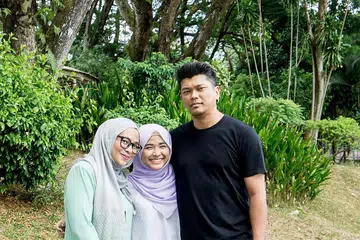 BERWIBAWA DAN BERWAWASAN: Nurul Aqilah Dahlan (tengah) berkata ibu bapanya Cik Norhayati Adris dan Encik Dahlan Manab sering mendorongnya agar sentiasa berbakti kepada masyarakat, selain menghulurkan bantuan terhadap mereka yang kurang bernasib baik dalam masyarakat. - Foto BH oleh NUR DIYANA TAHA