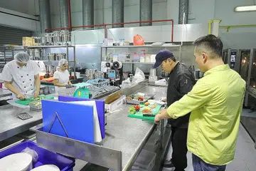 BERUBAH MENJADI BAIK: Encik Jamal (baju hijau) yang merupakan bekas pesalah dadah, kini sibuk mengurus perniagaan makanan keluarganya dan mengambil penghuni Darul Islah untuk bekerja di tempat perniagaannya. - Foto Fail
