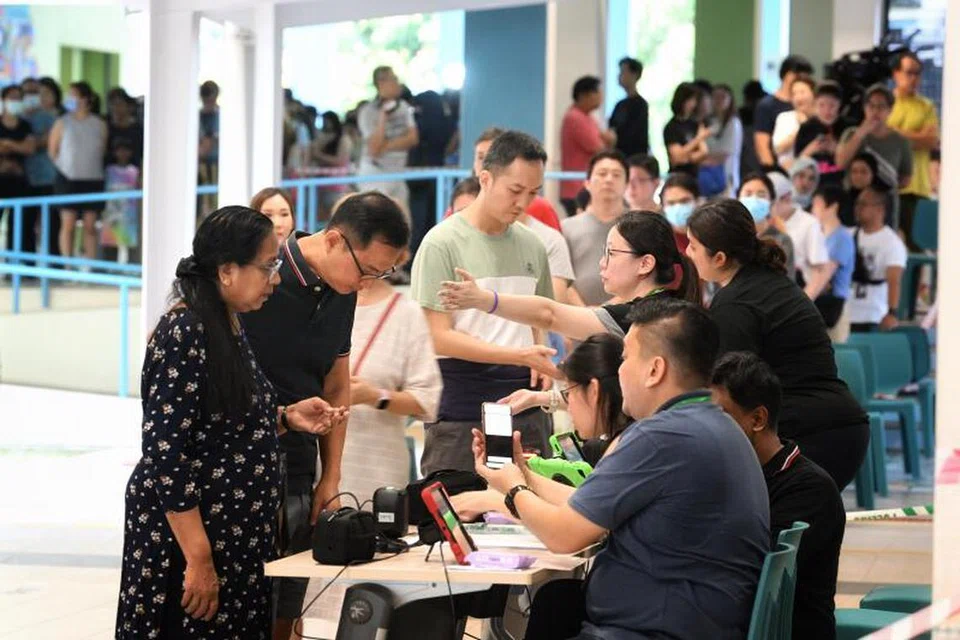 BERATUR SEBELUM MENGUNDI: Warga Singapura beratur dan mendaftar di pusat mengundi di Sekolah Rendah Waterway di Punggol.