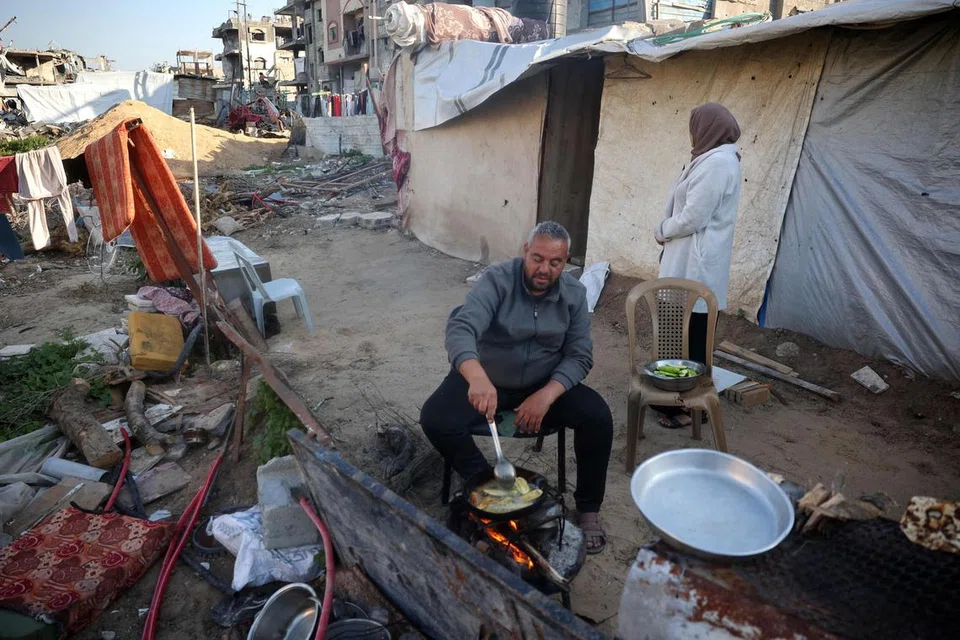 Seorang lelaki Palestin sedang memasak juadah berbuka puasa di luar tempat perlindungannya di kem pelarian Bureij, yang terletak di tengah Semenanjung Gaza, pada 11 Mac 2025 sempena bulan suci Ramadan.