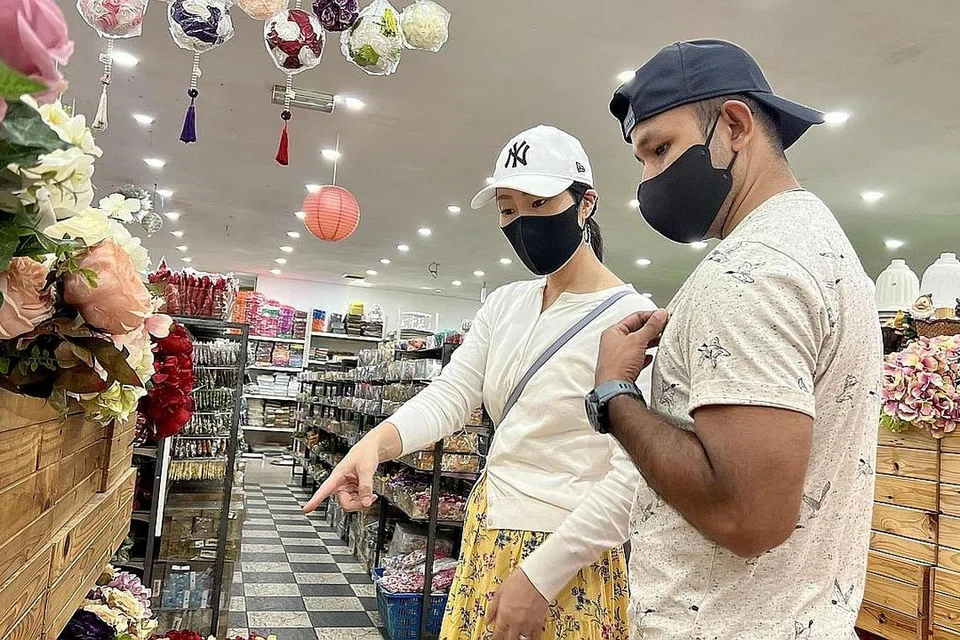 SENTIASA JIMAT: Memandangkan harga yang jauh lebih rendah, Encik Jufri bersama bakal isterinya Cik Saki Hareyama, meninjau keperluan hantaran untuk majlis persandingan mereka di seberang tambak. - Foto-foto BH oleh HANS ASHRIE DAUD 