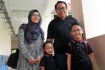 RINGANKAN BEBAN: Encik Mohd Hijazi Masderbari dan isteri, Cik Noor Susilawati Mohd Sanosi, lega dengan bantuan baucar Skim Bantuan Sekolah, Dana Amanah Pendidikan (ETF), yang diterima anak bongsu mereka, Muhd Rizq Wildan (hadapan kiri). Bersama mereka anak sulung, Rifqi. - Foto BM oleh ALPHONSUS CHERN
