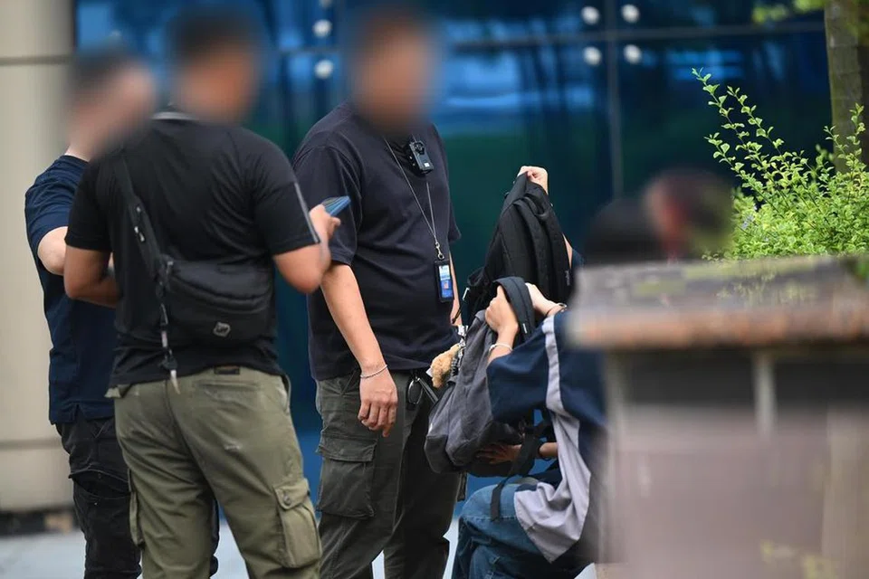 Pegawai Penguasa Sains Kesihatan (HSA) menyoal remaja di Pusat Sivik Woodlands pada 14 Julai, sebelum menggeledah beg mereka.