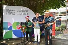 Setiausaha Parlimen Kanan (Kebudayaan, Masyarakat dan Belia merangkap Pembangunan Sosial dan Keluarga), Encik Eric Chua (tengah), yang hadir di Rumah Terbuka Enabling Village turut membuat persembahan sebuah lagu bersama StrawberryStory, kumpulan muzik yang dibentuk oleh dua artis kurang deria penglihatan, Cik Wan Wai Yee (kiri) dan Encik Ivni Yaakub (kanan) semasa sesi ‘LIVE with ART:DIS’ pada 30 November.