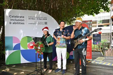Setiausaha Parlimen Kanan (Kebudayaan, Masyarakat dan Belia merangkap Pembangunan Sosial dan Keluarga), Encik Eric Chua (tengah), yang hadir di Rumah Terbuka Enabling Village turut membuat persembahan sebuah lagu bersama StrawberryStory, kumpulan muzik yang dibentuk oleh dua artis kurang deria penglihatan, Cik Wan Wai Yee (kiri) dan Encik Ivni Yaakub (kanan) semasa sesi ‘LIVE with ART:DIS’ pada 30 November.