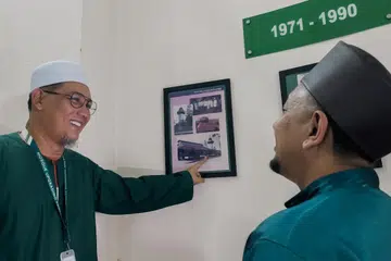 Pengerusi Masjid Alkaff Kampung Melayu, Encik Mohamed Faizul Othman (kiri) menunjukkan pintu masuk yang selalu digunakannya pada lewat 1980-an kepada Pengurus Masjid Alkaff Kampung Melayu, Ustaz Mohd Taufiq Ismail (kanan).