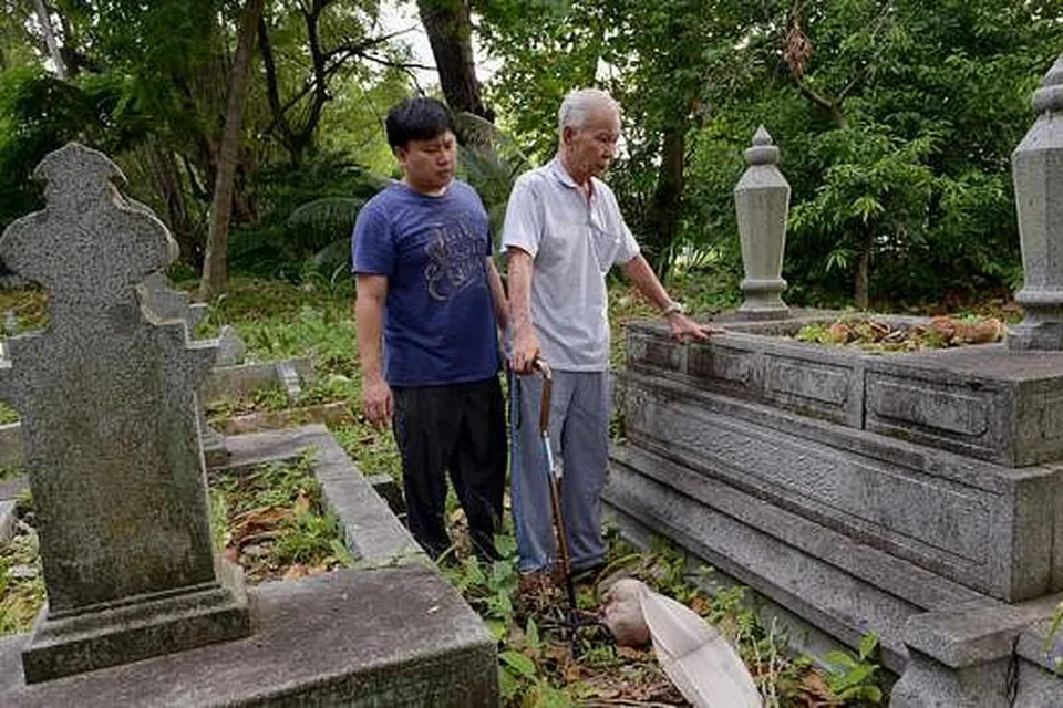 PERKUBURAN SENDIRI: Encik Burhan ditemani anaknya, Encik Muhamad Fadzil, seorang ejen hartanah, menziarahi kubur kaum keluarganya di tanah perkuburan di belakang Masjid Malabar, dekat Jalan Kubor. 