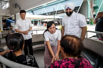 Menteri Pengangkutan, Encik Chee Hong Tat (kiri), bersama dua wajah baru Parti Tindakan Rakyat (PAP), iaitu pengarah eksekutif, CampusImpact, Cik Elysa Chen, dan peguam yang juga rakan kongsi di firma guaman, Tito Isaac & Co, Encik Kawal Pal Singh, semasa mengunjungi Pasar dan Pusat Makanan Toa Payoh West pada 13 April.