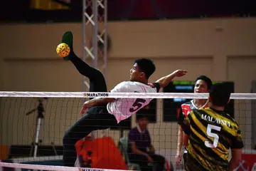 RAIH PENGALAMAN: Pemain Singapura Khairul Fahmi Yazid membuat serangan libas ketika menentang Malaysia dalam acara regu lelaki di Sukan SEA 2023 pada Selasa. - Foto MAJLIS KEBANGSAAN OLIMPIK SINGAPURA