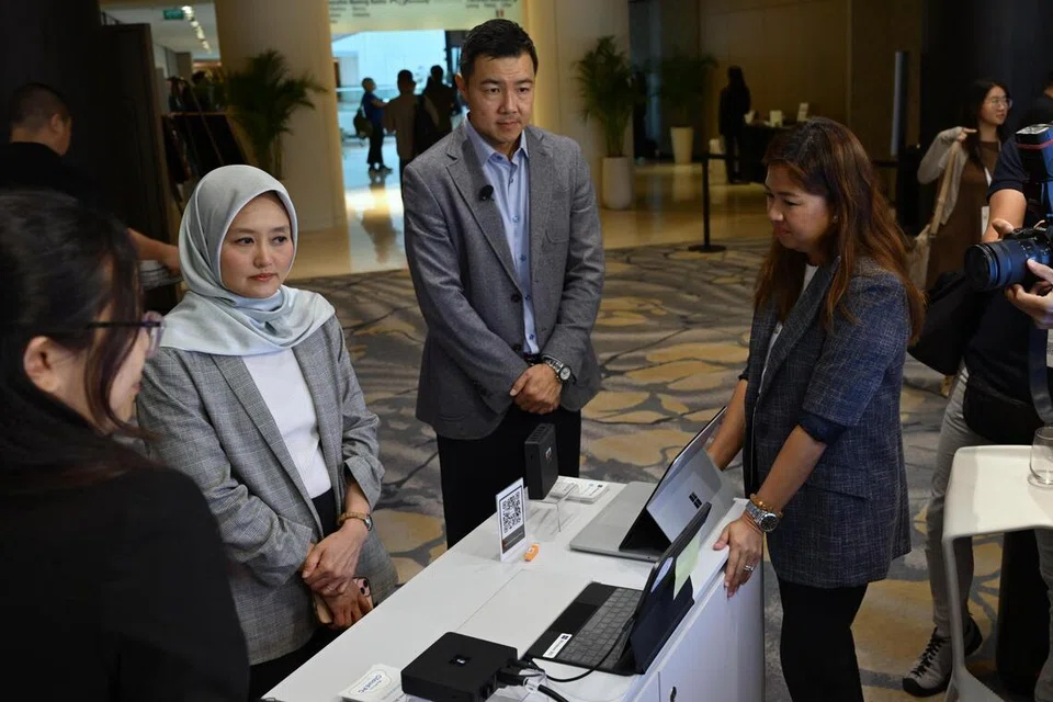Menteri Negara (Penerangan dan Pembangunan Digital merangkap Kesihatan), Cik Rahayu Mahzam (dua dari kiri), meninjau peranti Windows 365 Link yang baru dilancarkan bagi pasaran Singapura sempena Hari Penyelesaian Sektor Awam Microsoft 2026 pada 9 April. Bersama beliau ialah Pengarah Urusan, Microsoft Singapore, Encik Wee Luen Chia.