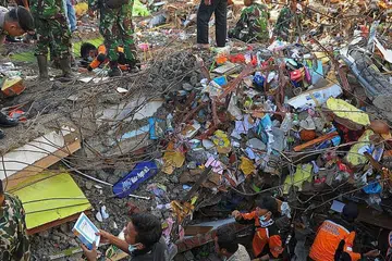 GIGIH CARI MANGSA: Pasukan mencari dan menyelamat Indonesia sedang mencari mangsa di bawah timbunan runtuhan bangunan selepas kejadian gempa di Aceh awal pagi kelmarin. - Foto AFP 