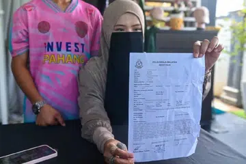 Ibu pelajar mangsa buli, Cik Siti Rohani Yusof, 40 tahun, menunjukkan laporan polis yang dibuat mendakwa anak lelakinya dibuli di sebuah sekolah agama di Rompin, Pahang.