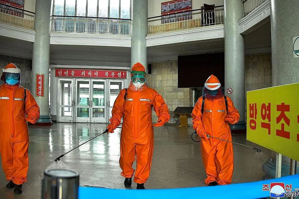 LAKUKAN PEMBERSIHAN: Kakitangan stesen kereta api sedang melakukan pembasmian kuman di premis stesen Pyongyang sebagai langkah pencegahan terhadap Covid-19. - Foto AFP