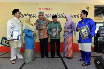 JASA DIKENANG: Dr Yaacob (tiga dari kiri) dan ketua pegawai eksekutif Yayasan Mendaki Cik Tuminah Sapawi (dua dari kanan) menyampaikan pengiktirafan kepada 23 relawan Mendaki dalam majlis semalam, termasuk (dari kiri) Encik Muhammad Sufi Sayuti, Cik Wahizah Wahid, Encik Salim Suri dan Encik Muhammad Firdaus Kamaludin Jamal. - Foto M.O. SALLEH