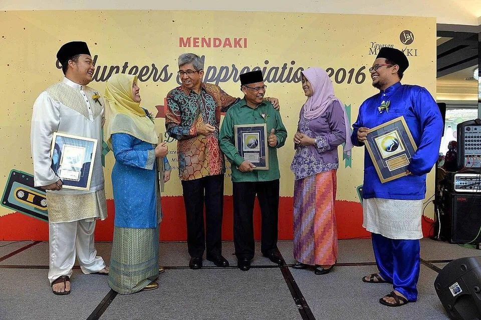 JASA DIKENANG: Dr Yaacob (tiga dari kiri) dan ketua pegawai eksekutif Yayasan Mendaki Cik Tuminah Sapawi (dua dari kanan) menyampaikan pengiktirafan kepada 23 relawan Mendaki dalam majlis semalam, termasuk (dari kiri) Encik Muhammad Sufi Sayuti, Cik Wahizah Wahid, Encik Salim Suri dan Encik Muhammad Firdaus Kamaludin Jamal. - Foto M.O. SALLEH