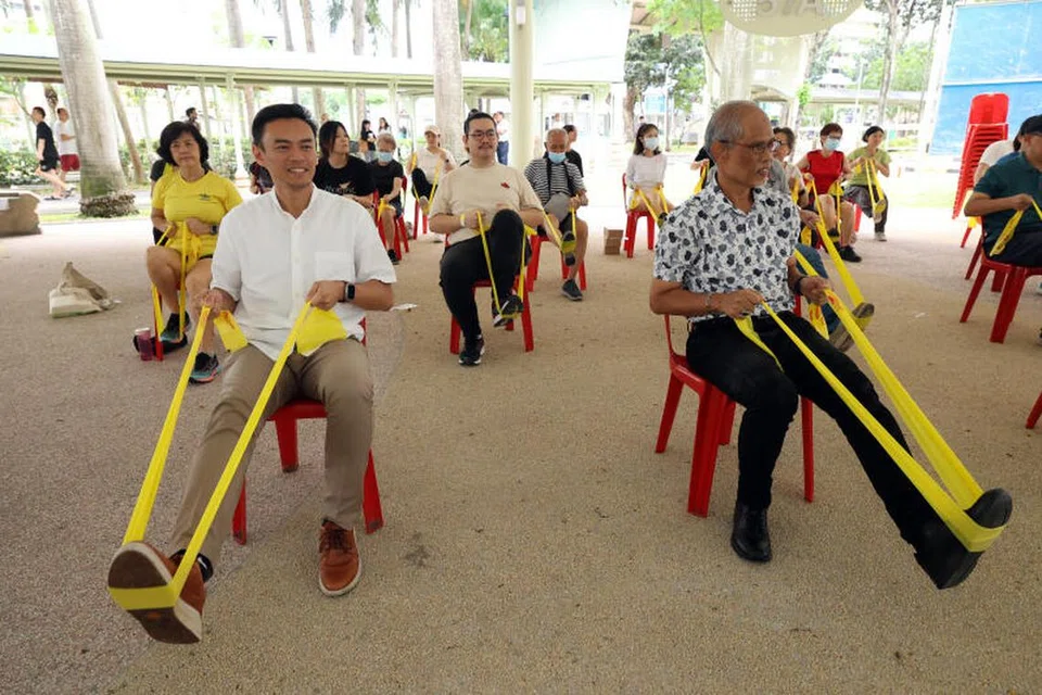 HIDUP AKTIF: Encik Masagos (kanan) dan Dr Wan Rizal (kiri) pada Ahad bersenam bersama penduduk Kolam Ayer, iaitu salah satu inisiatif untuk mengamalkan gaya hidup sihat di kawasan itu.  
