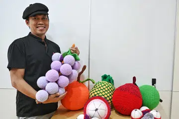 Encik Rafadi Basri, 57 tahun, yang lebih senang dikenali sebagai Camy, menunjukkan ‘buah-buahan’ yang dikaitnya untuk pameran Hari Kebangsaan.